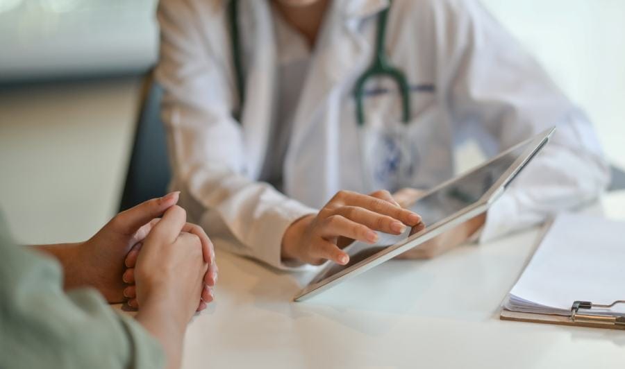 Shot of a doctor showing a patient some information on a digital tablet